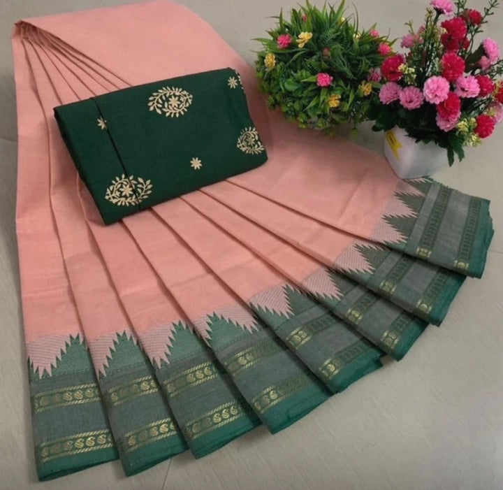 Pink and green saree with a matching blouse piece, accompanied by flowers on a light background.